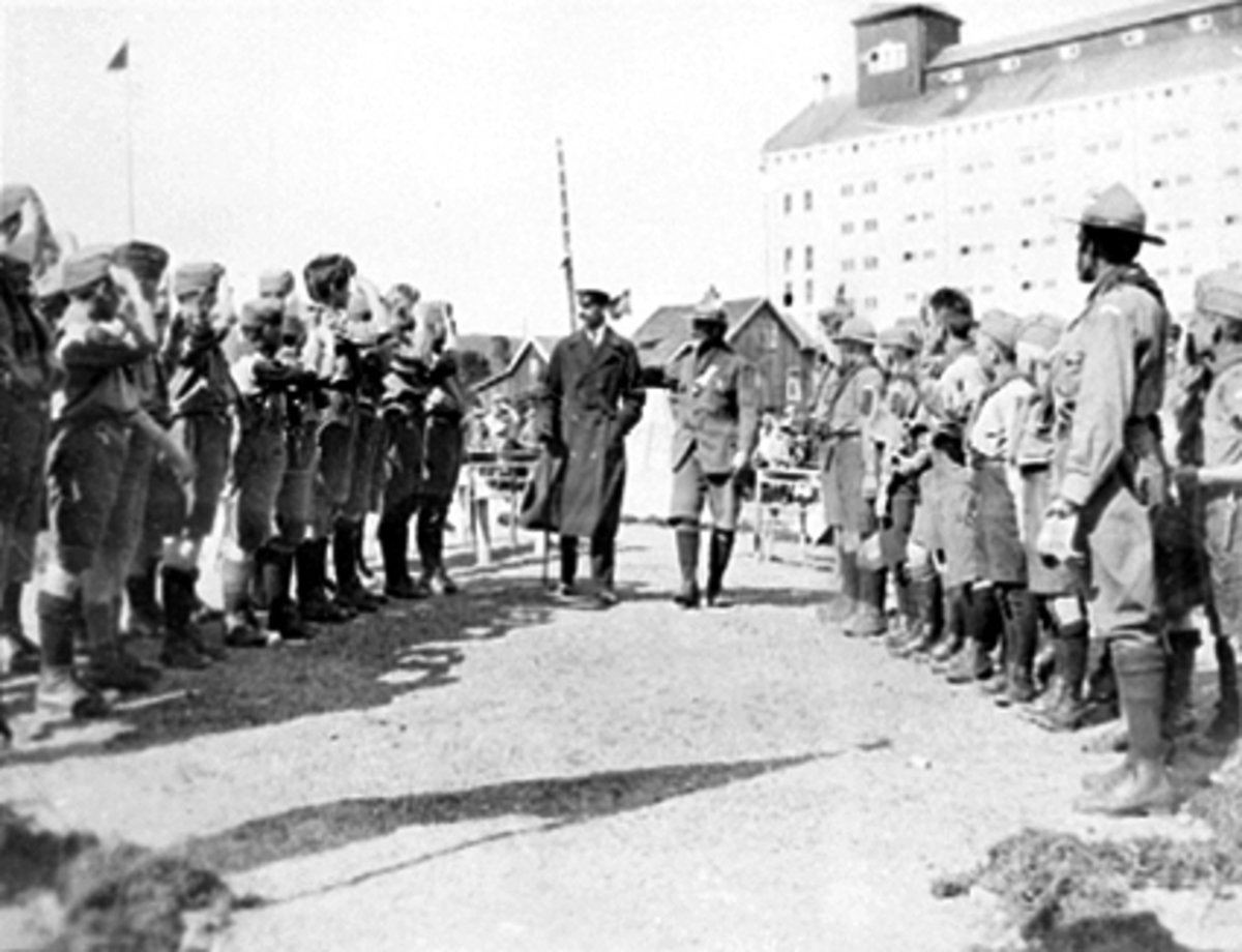 Anno Domkirkeodden, LANDSLEIR FOR SPEIDERE PÅ MARTODDEN PÅ STORHAMAR, H. M. KONG HAAKON VII HILSER PÅ SPEIDERTROPPER FRA LØTEN, NES, EIDSVOLD OG TRETTEN. T. h. for kongen speidersjef Hans Møller Gasman.