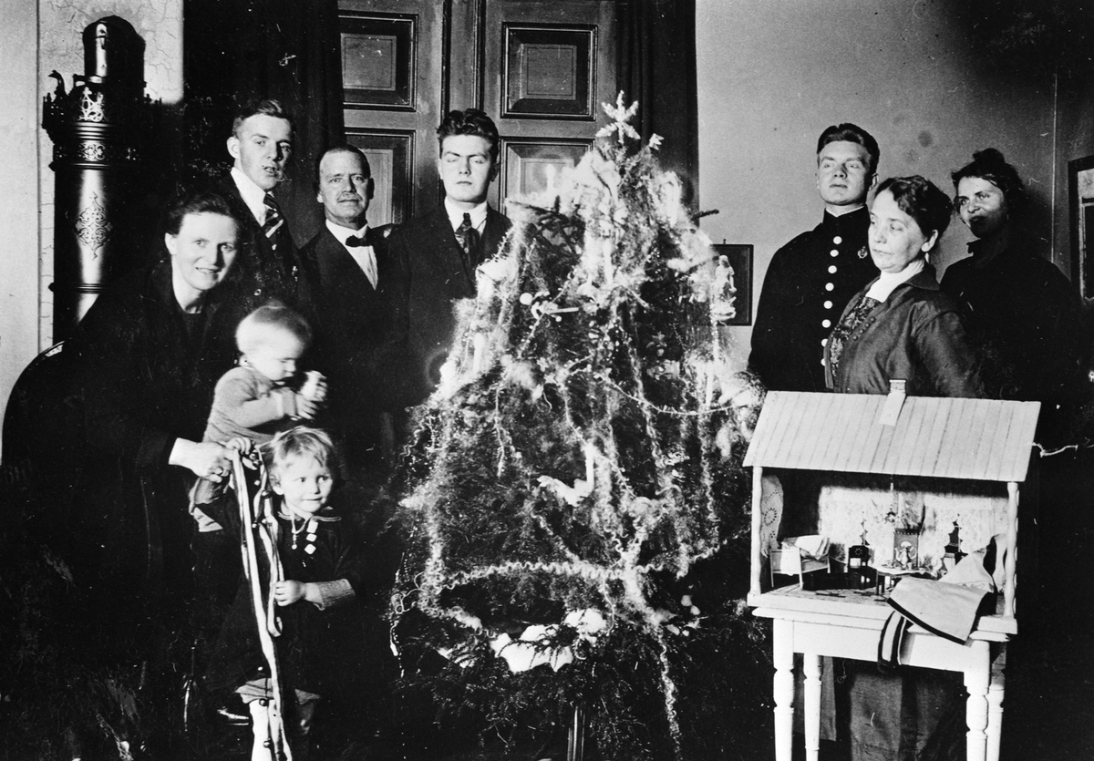 Anno Domkirkeodden, INTERIØR STUE MED JULETRE, JULAFTEN, FAMILIEN LØKEN RUNDT JULETREET, JULEKRYBBE I FORGRUNNEN.