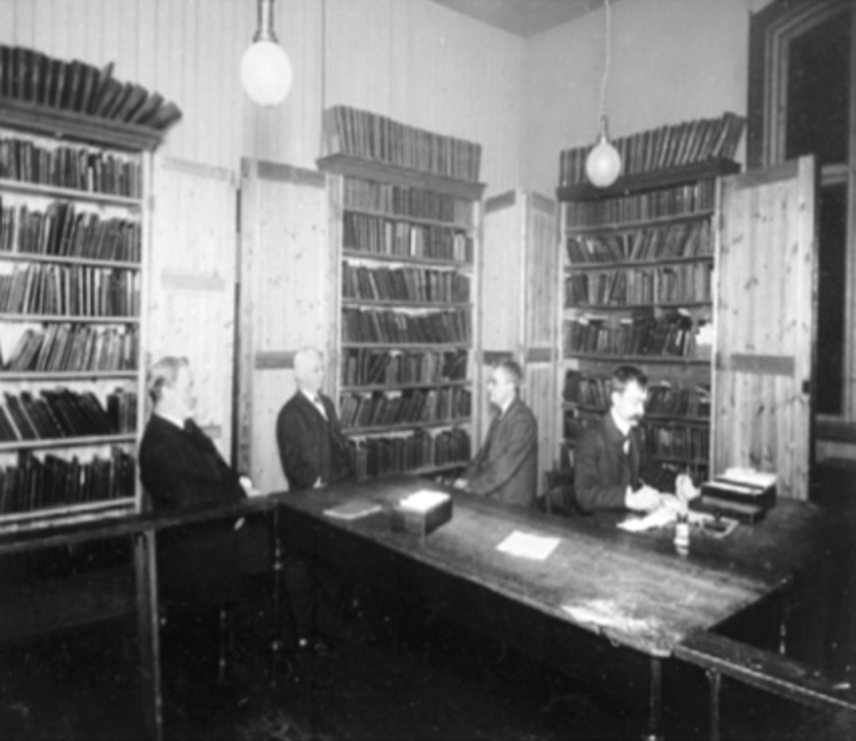 Anno Domkirkeodden, INTERIØR, HAMAR FOLKEBIBLIOTEK, GRUPPE V/SKRIVEBORD, MIDTBYENBiblioteket:Brannvakta/Midtbyen 1888-1890, Håndverkeren, Parkgt. 1890-1892, Midtbyen skole 11892-1909, Håndverkeren Parkgt. 1909-1925, Samlagsgården Torggt. 63 1925-1943 brann, Midtbyen skole 1943-1947, Pikeskolen 1947-1952, Handelens hus…