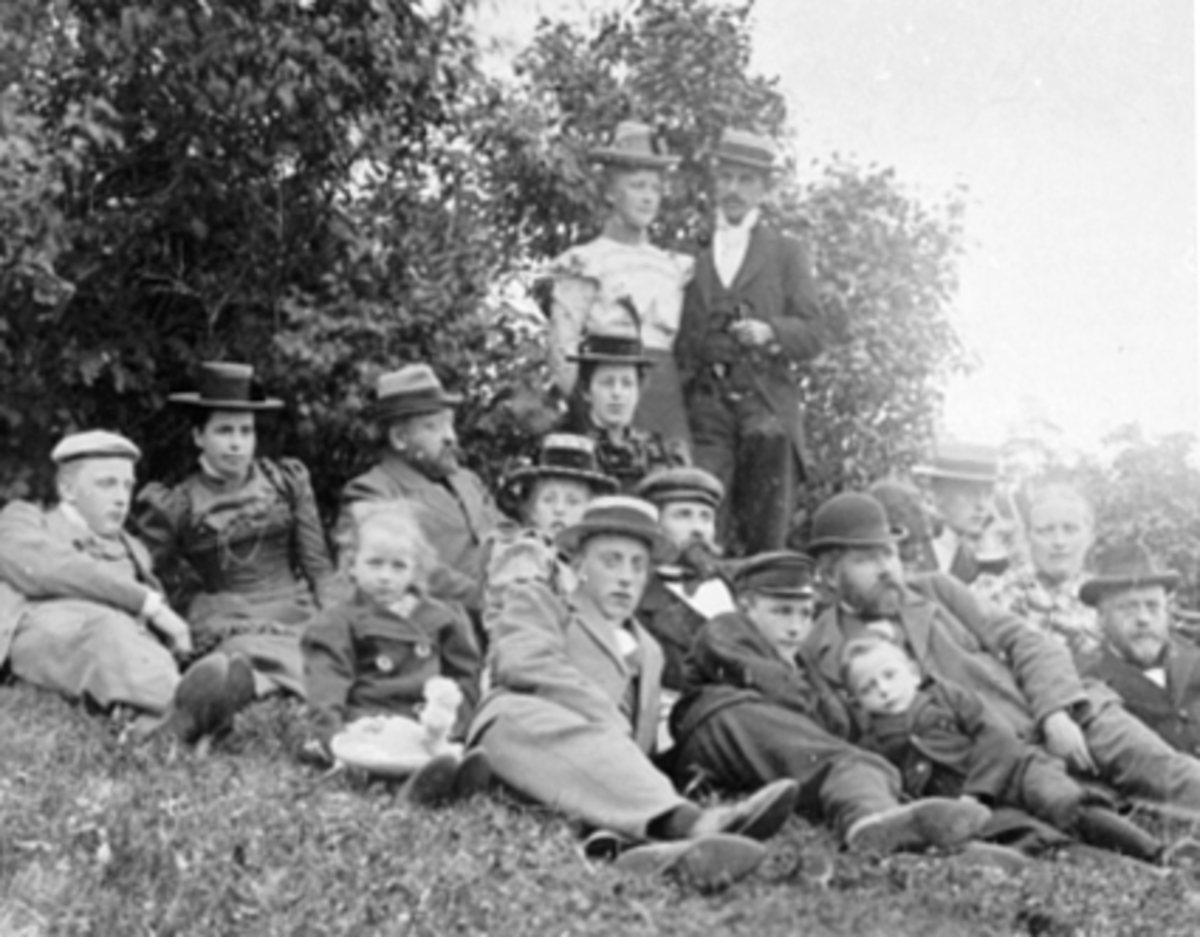 Anno Domkirkeodden, Gruppe 16, familiene Andersen, Toresen, Godager, Dahl, Nielsen. Forlovelsesselskap Torsheim, Alvdal 13.08.1899. Bakerst stasjonsmester Andersen m/hustru Petra, Lensmann Torsen m/frue, datter Helga, sønner Olaf, Ragnvald og Halfdan. Godager m/frue, Ola Dahl m/sønnen Ola Nielsen m/frue, Petra og Thor…