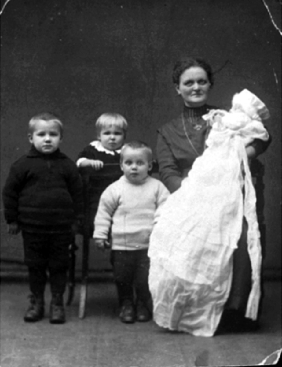 Anno Domkirkeodden, Karen Hansen, fadder for Fritz Kristiansen, barnedåp, dapskjole. Fritz var sønn av Dina og August Kristiansen. De tre andre barna er søskene til Fritz.