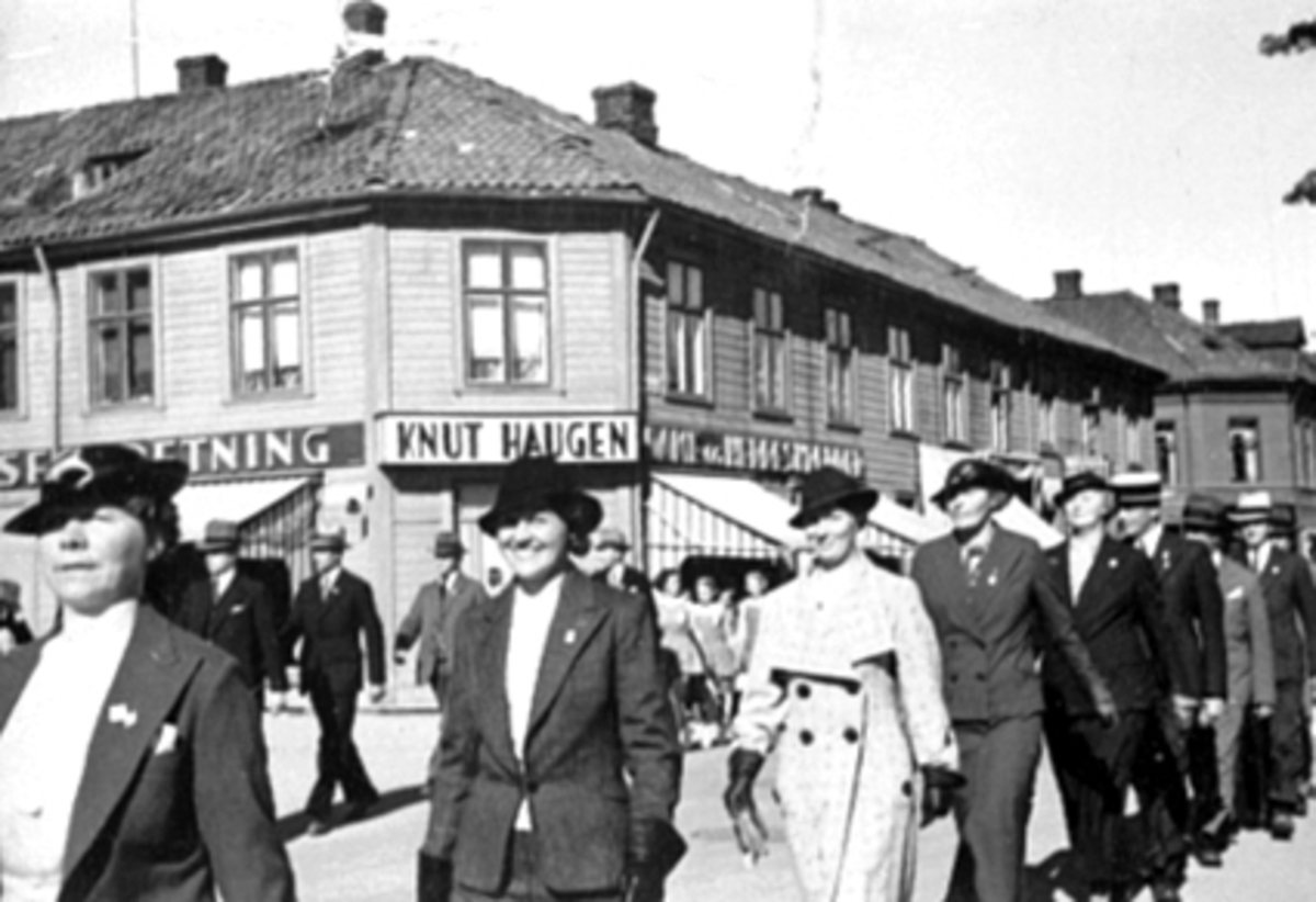 Anno Domkirkeodden, Borgertoget 17.mai 1930årene. Knut Haugens forretning i Strandgata 71, Hamar. Fra v: Dorthea Falkenberg, Astrid Norderhaug, Aase Solli, Jenny Knutsen, Olga Fuglseth, RIttmester Grinaker, ukjent, Bjørn Norderhaug.
