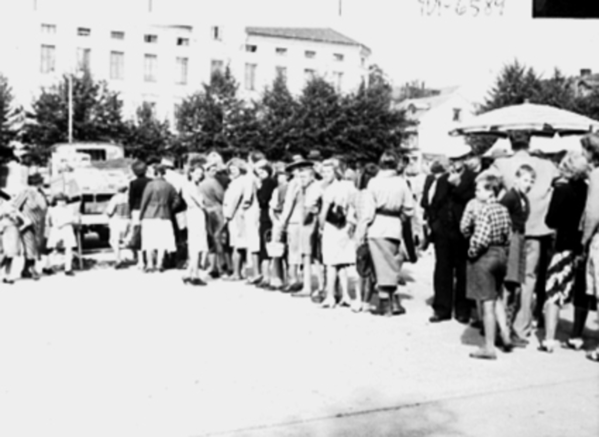 Anno Domkirkeodden, Torgkø, potetkø, under krigen, lastebil m/varer, torghandel, Åsgårdene. Stortorget i Hamar. Ebba Hjorth g. Lauritzen jente m/lys kjole midt i bildet, foran henne Odd Andersen. 2. verdenskrig.