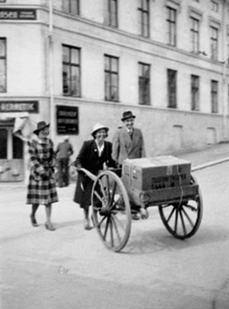 Anno Domkirkeodden, Gunhild Bergstrøm har vært på Misjonshuset og hentet radioen sin. Håndkjerre hadde hun lånt av agent Finstad. T.v. Dagny Rølles, th. Kristian Brandal. Fredsdagene 1945.