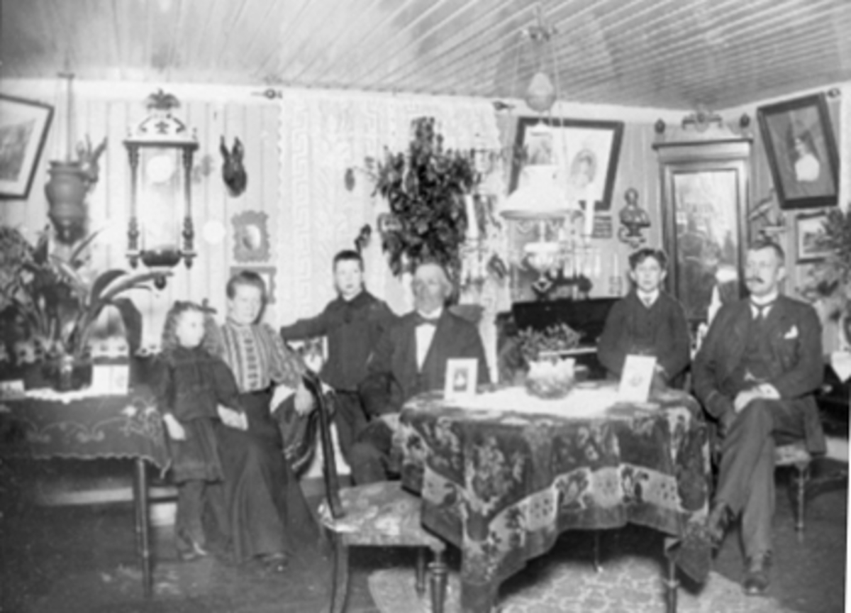 Anno Domkirkeodden, Interiør stue. Hjemme hos "Enok kjører" Vognmann Enok Jensen, bodde i det vesle huset ved siden av Godtemplarlosjen i Håkonsgate. F.v. Margot Jensen, fru Jensen, Jarl Jensen, Vognmann Enok Jensen, ukjent, ukjent.