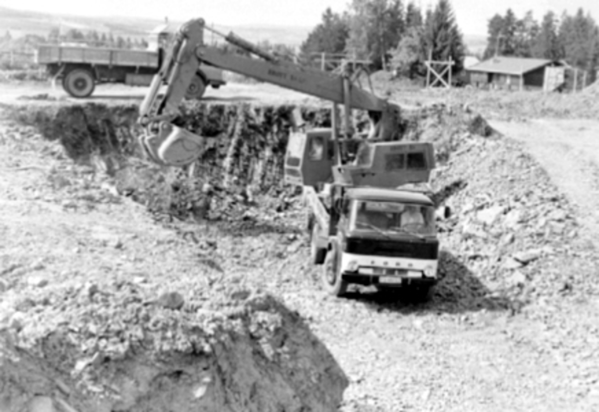 Anno Domkirkeodden, NORSK TIPPING A/S, UTGRAVING AV KJELLER, GRAVEMASKIN OG LASTEBILER, 15. 06. 1973. JØNSRUDVEGEN 21 PÅ STORHAMAR. HAMARARKITEKTEN CHR. LINDMAN TEGNET DET NYE BYGGET, OG INNFLYTTINGEN SKJEDDE I 1975. I forgrunnen en Ford D-serie, som var i produksjon 1965-80