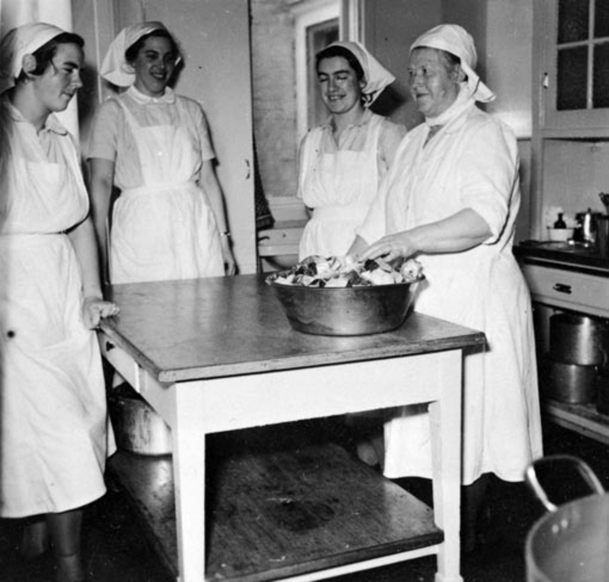 Anno Domkirkeodden, HAMAR RØDE KORS KLINIKK. GRUPPE 4 KJØKKENPERSONALET. KJØKKENSJEF RAGNHILD NYJORDET T. H. SE FORØVRIG ARTIKKEL I HAMAR STIFTIDENDE MARS 1954.