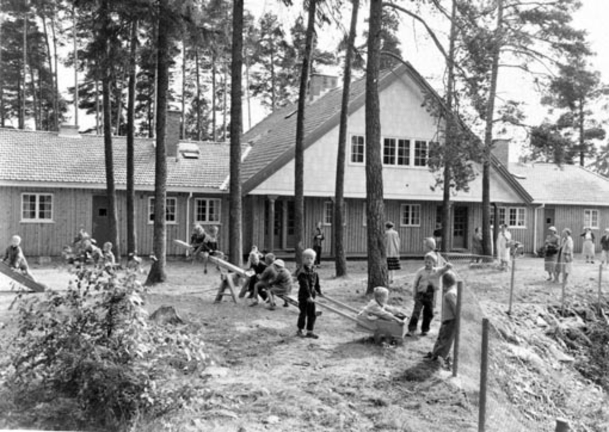 Anno Domkirkeodden, HAMAR RØDE KORS BARNEHAGE. EKSTERIØR BARN I LEK. FOTO NORMANN, HAMAR 18. 9. 1954FLERE OPPTAK BARN I AKTIVITET INNENDØRS+ VOKSNE GRUPPE 3 KVINNER SE NEG. NR. NO-51486
