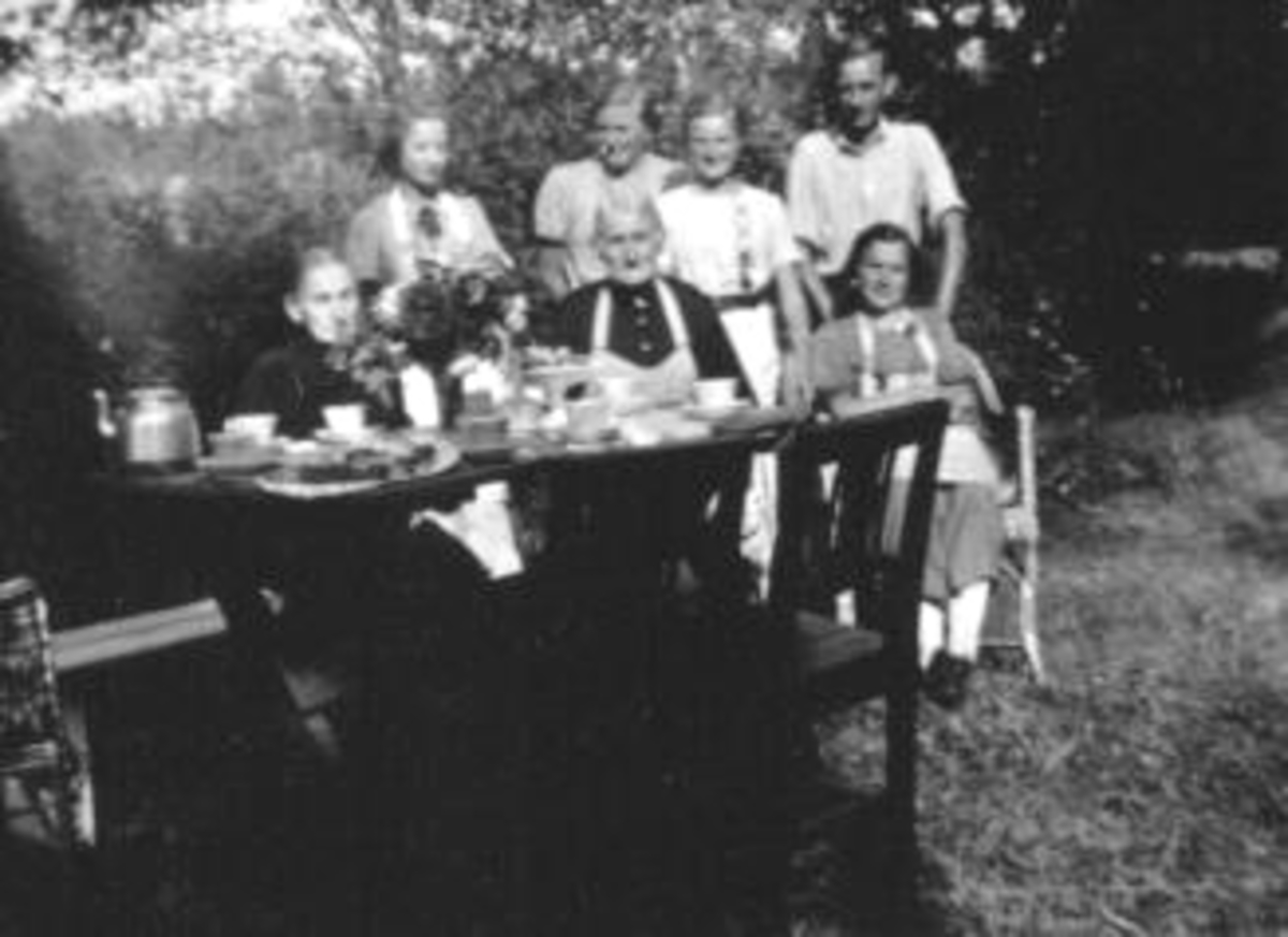 Anno Domkirkeodden, Gruppe personer rundt dekket kaffebord i hagen.