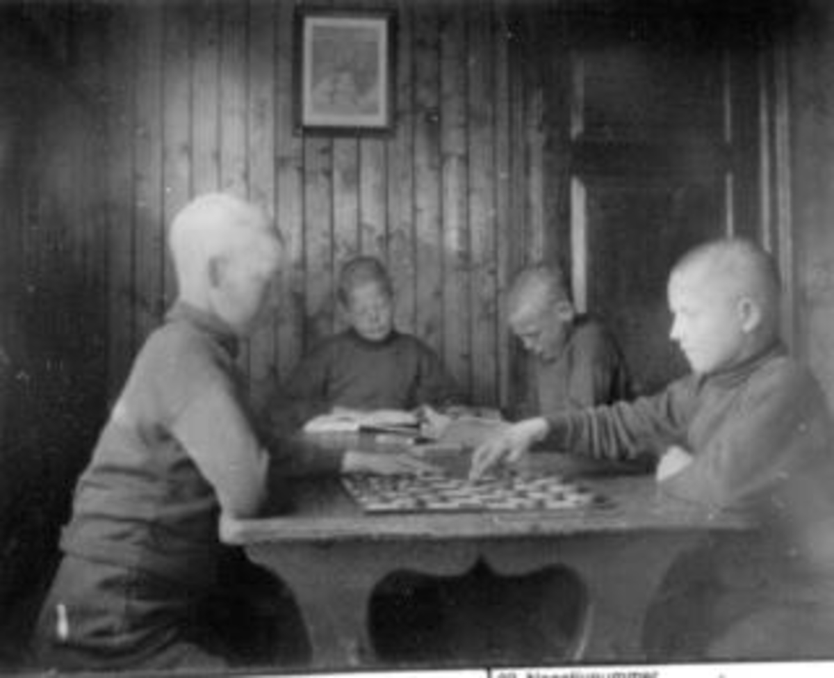 Anno Domkirkeodden, Interiør fra Toftes Gave, Nedre Sund, Helgøya. Gutter som leser og spiller spill.