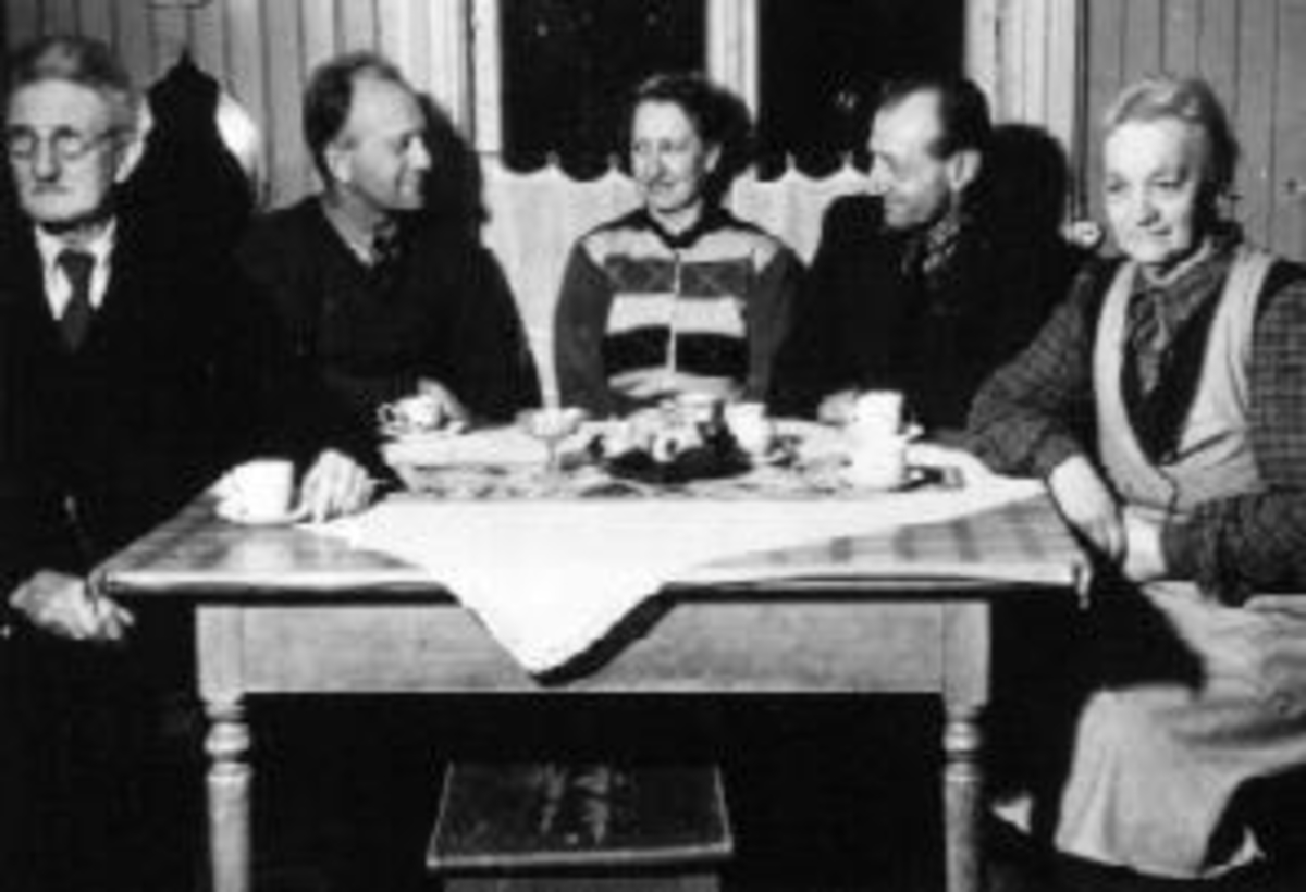 Anno Domkirkeodden, Interiør, kjøkken. Ved kjøkkenbordet er Even Olsen Bratberg (1874-1953), Georg Bratberg (1907-1991), Aslaug Bratberg (1905-1981), Ottar Bratberg (1902-1987), Mathilde Bratberg (1881-1956).