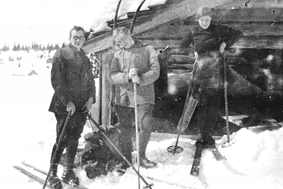 Anno Domkirkeodden, Tre personer på ski foran "Hotel Mikkelsrud", laftet tømmerhytte på Ringsakerfjellet. Vinter, fritid, påske.