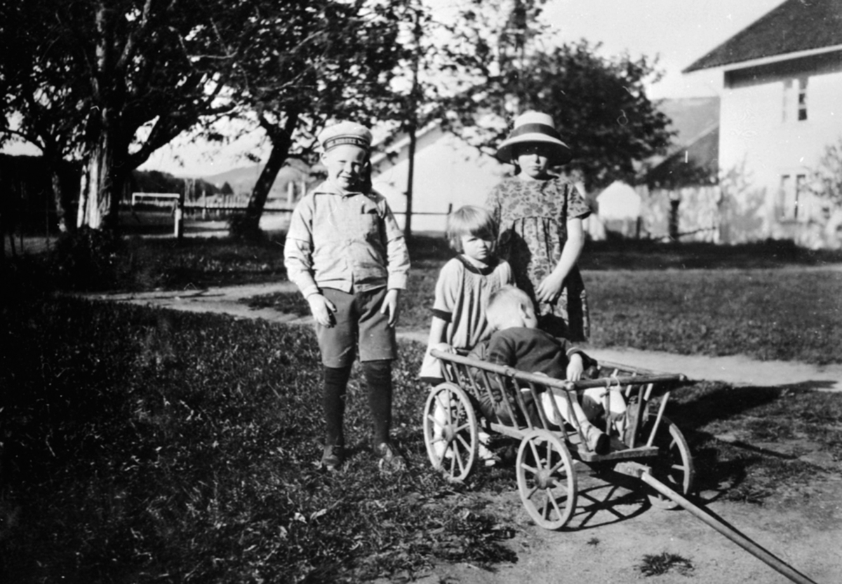Anno Domkirkeodden, Fire barn i lek med vogn. Hans, Vesla, Margrethe Løken, Karl Alf Løken på Granerud gård, Brumunddal.