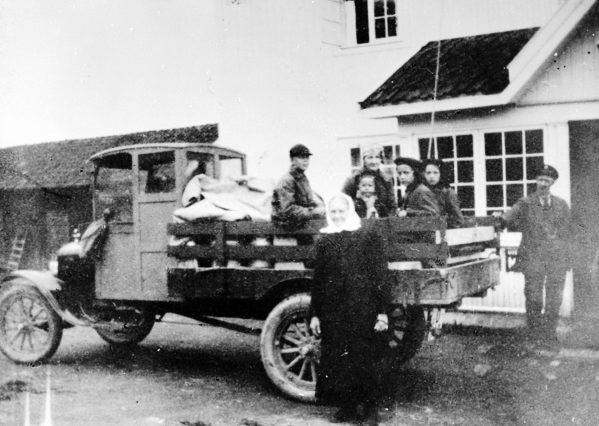 Anno Domkirkeodden, Tur til Sjusjøen med lastebil, en Ford 1921 modell. På lasteplanet fra venstre er Johan Mangerud, Agnethe Mangerud med Sverre Mangerud på fanget, Borghild Mangerud, Helga Mangerud. Foran er Agnetha Mosengen. Til høyre er sjåfør Gunnar Kinde. Utenfor J.B. Mangeruds forretning på Brøttum, Ringsaker.