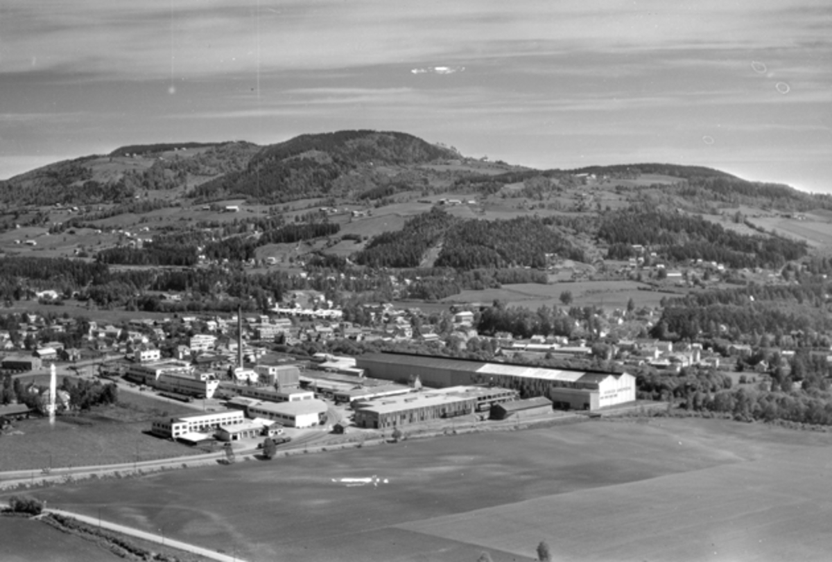 Widerøes Flyveselskap A/S, Flyfoto av Brumunddal med Berger Langmoen AS i forgrunn og Høsbjøråasen i bakgrunn.