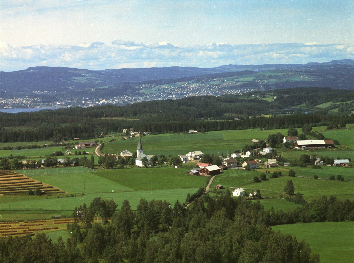 Widerøes Flyveselskap A/S, Flyfoto, Stavsjø kirke, sentrum, Nes, Hedmark. Gjøvik i bakgrunnen.