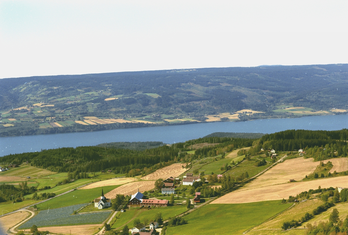 Widerøes Flyveselskap A/S, Flyfoto av Brøttum kirke med Mjøsa og Oppland i bakgrunnen.