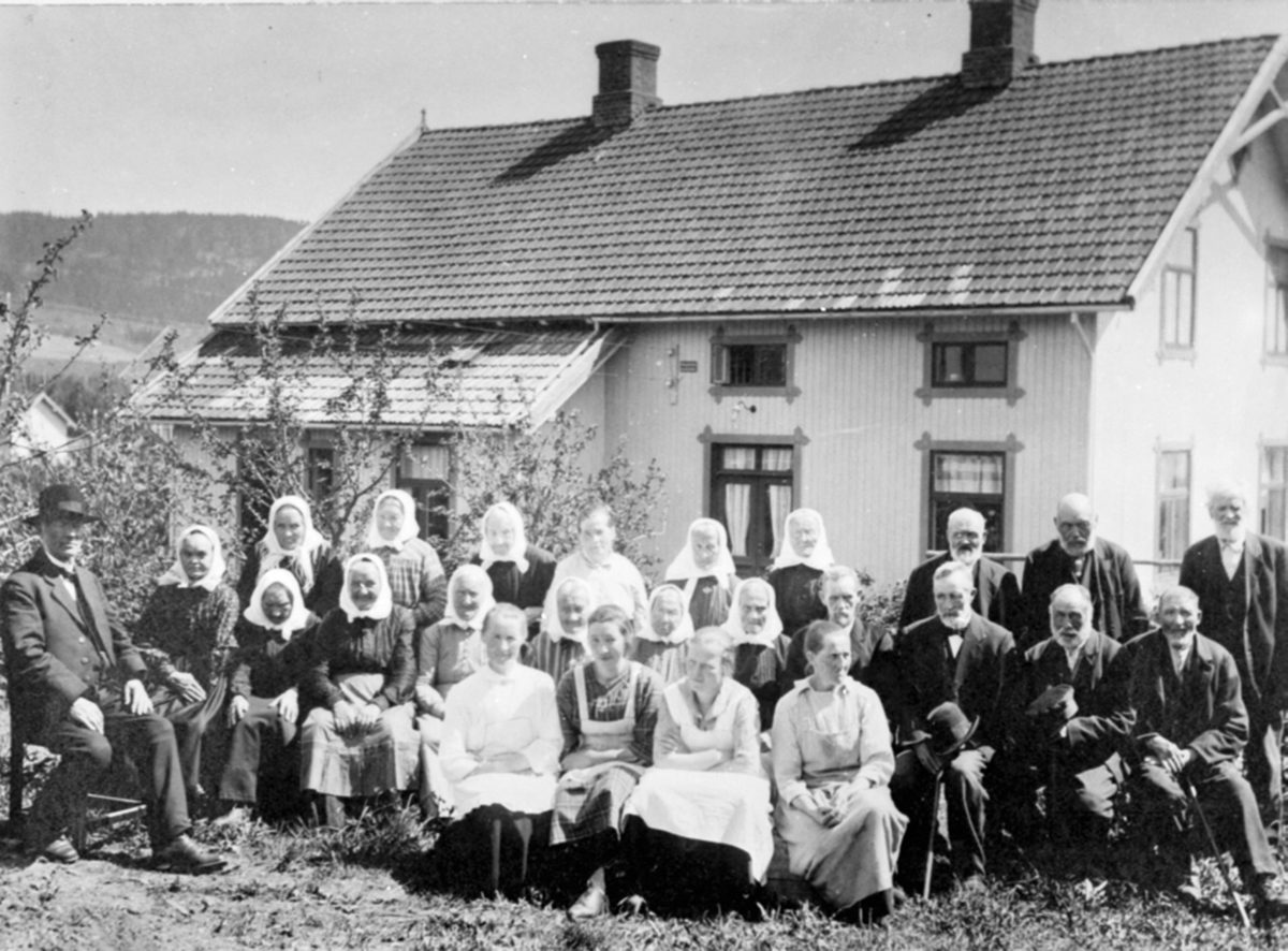 Anno Domkirkeodden, 24 personer utenfor Veldre gamlehjem (Fagertun under Koss), Byflaten, Ringsaker. Pastor Reinert Svendsen sitter til venstre.