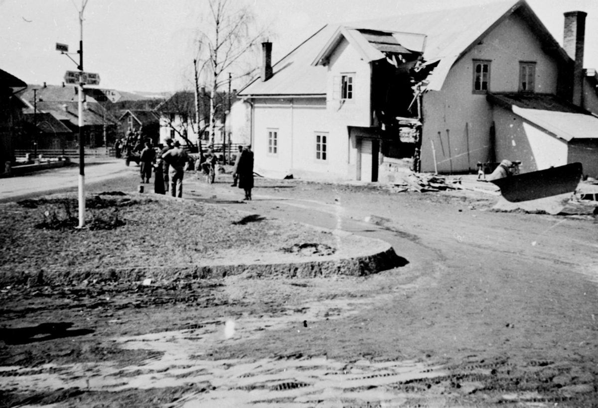 Anno Domkirkeodden, Buttekvern mølle, Brumunddal, truffet av granater under krigen, 19. april 1940, folk ser på tyske soldater som passerer.