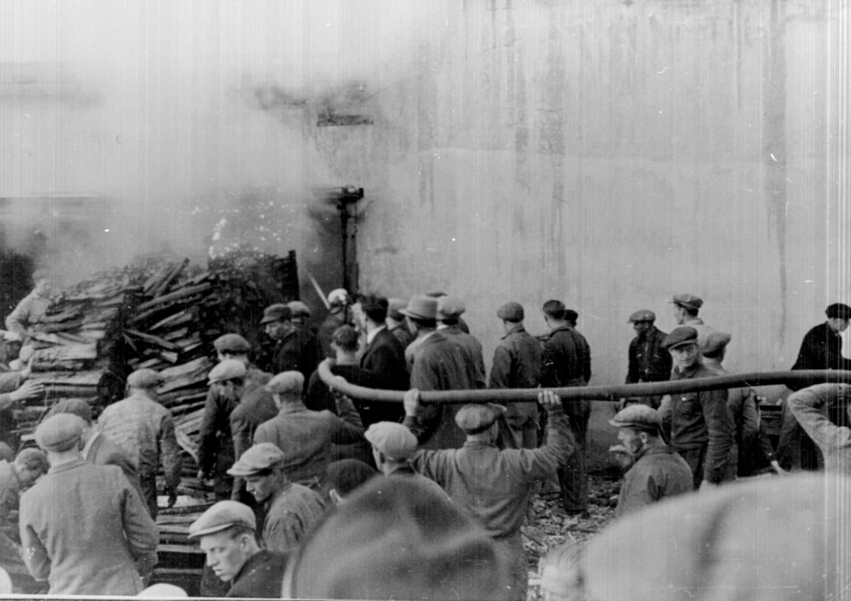 Anno Domkirkeodden, Brann ved Berger Langmoen A/S, Brumunddal. Arbeidere hjelper til med slukningsarbeidet. Brannen var i 1934.