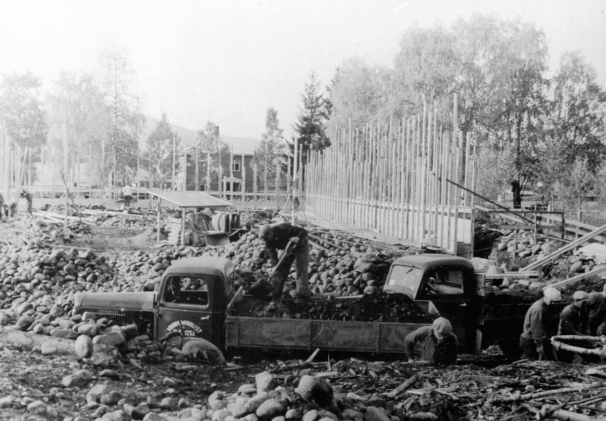 Anno Domkirkeodden, Utgraving av tomt til wallboardfabrikken ble gjort for hånd, 2 lastebiler, arbeidere, Berger Langmoen A/S, Brumunddal. Lastebil fra Vognmann Winquist, Hamar. Stein og jordarbeidere.