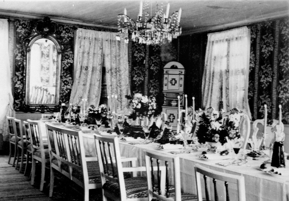 Anno Domkirkeodden, Interiør, storslaen på Nerkvern gård, Brumunddal. Pyntet til Thore Bjerkes barnedåp. Dekket langbord, speil,lyskrone, hjørneskap. Lille Thore var en eldre bror av Tom.