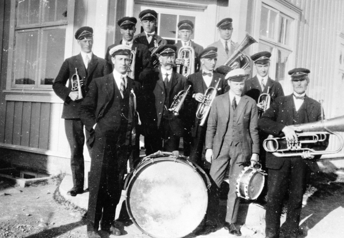 Anno Domkirkeodden, Brumunddal Musikkforening. Foran venstre er Johannes Sørlien, Fredrik Græsby, Sigurd Evensen, Nils Johansen Hegre. I midten er Hans Bakken, Johan Røhne. Bak er Haakon Græsby, Hans Stordahl, Per Hangenholen, Hans Berger, Martinus Larsen, 17. mai, posthustrappa, Brumunddal.