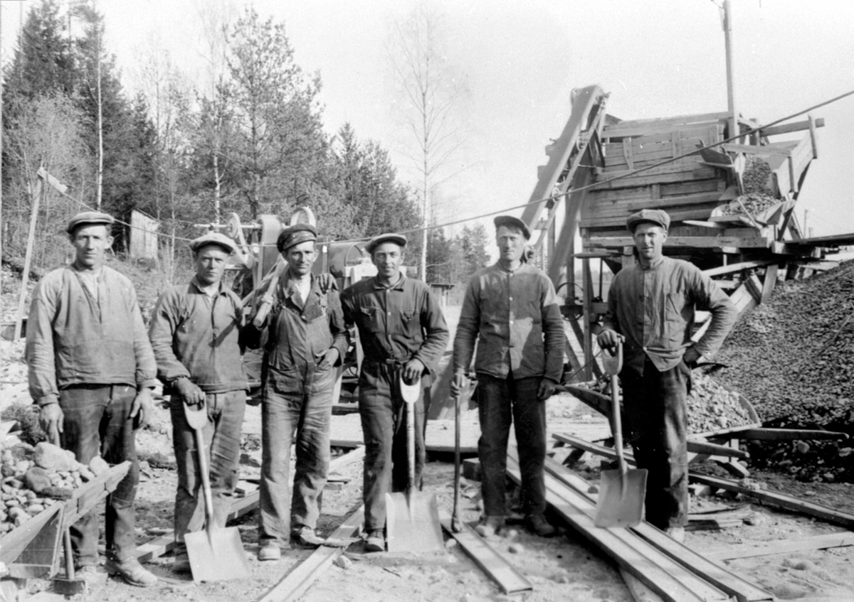 Anno Domkirkeodden, Gruppe arbeidere anleggsarbeid med slegge og spader. Sorteringsverk og sementblander. Andreas Murstad, Birger Bekkevold, Kvernvolden, Ernst Thoresen Ingvald Iversen, Johannes Sølvsberg, Furnes, Ringsaker.