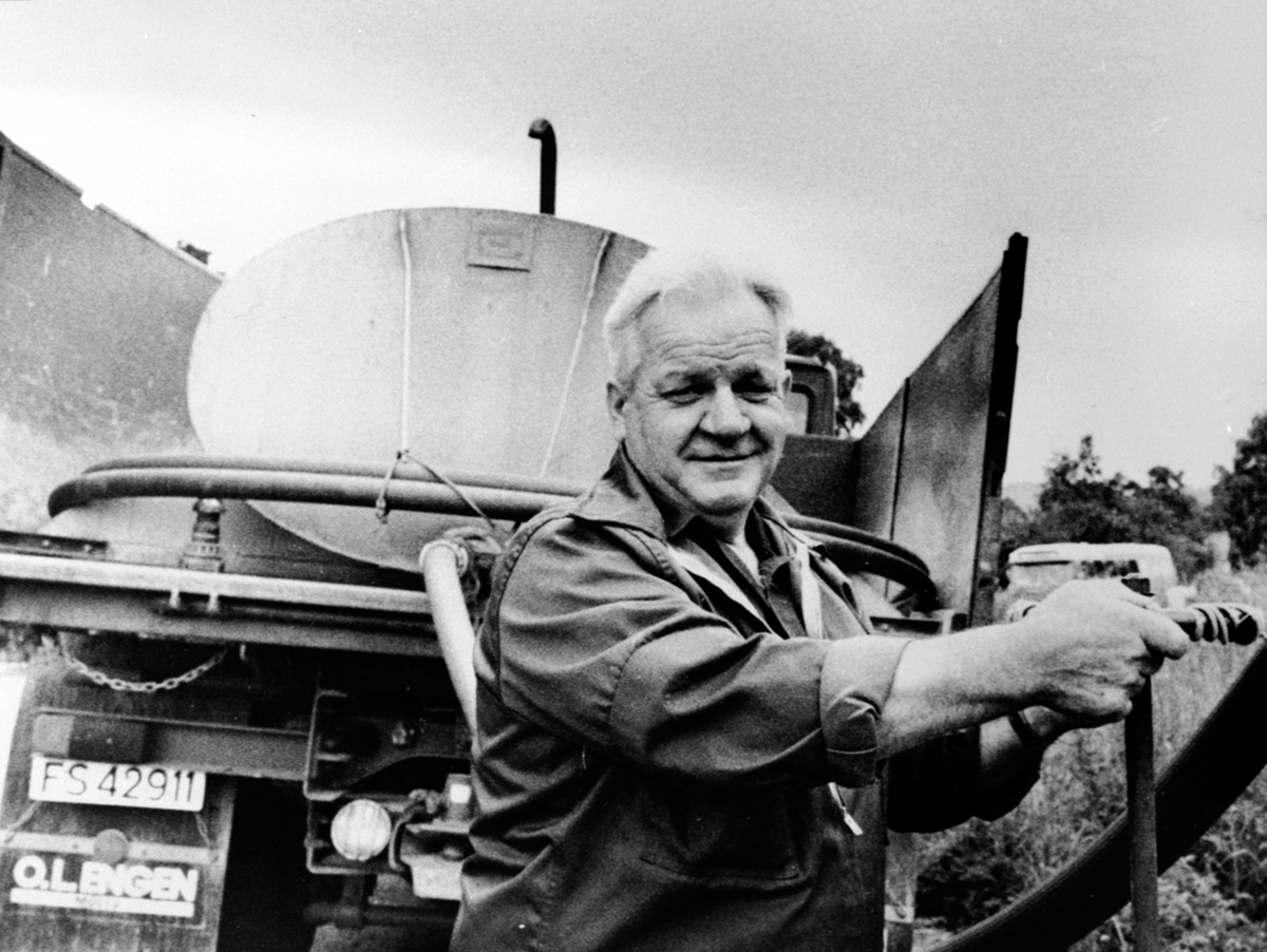 Anno Domkirkeodden, Lastebileier Einar Langdalen fyller vann på vanntanken på lastebil, FS-42911, Brumunddal. "Einar Langdalen, en av Brumunddals mange sjåfører. I 1984 kjørte han fortsatt vann til husstander som ikke hadde det innlagt "