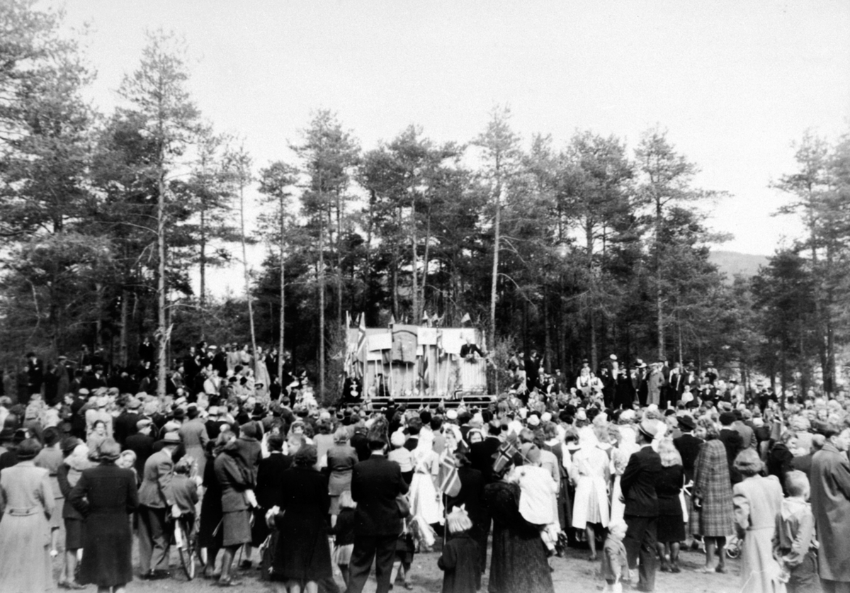 Anno Domkirkeodden, Sekretær i sjømannsmisjonen, prest Ingard Henriksen taler den 17. main 1946. Mye folk ved pyntet scene, Moelv.