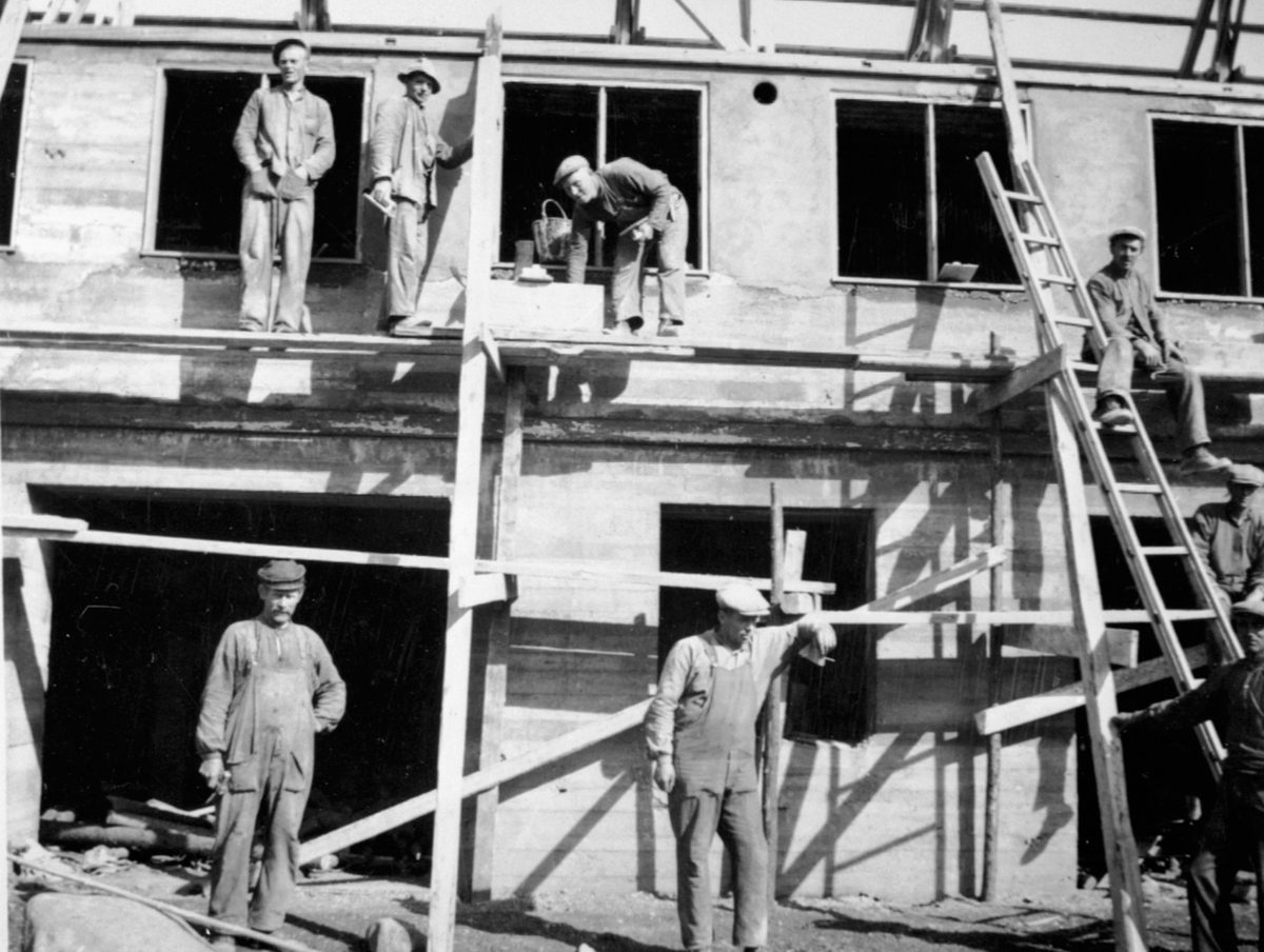 Anno Domkirkeodden, Bygging av ny driftsbygning på Hovelsrud, Helgøya etter brannen i 1934. 8 håndverkere i arbeid.