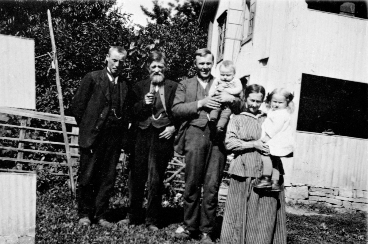 Anno Domkirkeodden, Familie på Raknerud søndre, Helgøya utenfor den gamle hovedbygningen da garden var udelt. Fra venstre er Rudolf Raknerud (1884-1965), Even Berntsen Raknerud f.1854, Martin Langseth (1893-1978) med Otto Langseth f. 1919 på armen, Betsy Evensdatter Langseth (1893-1974) med Ragna Langseth f.1918 på ar…