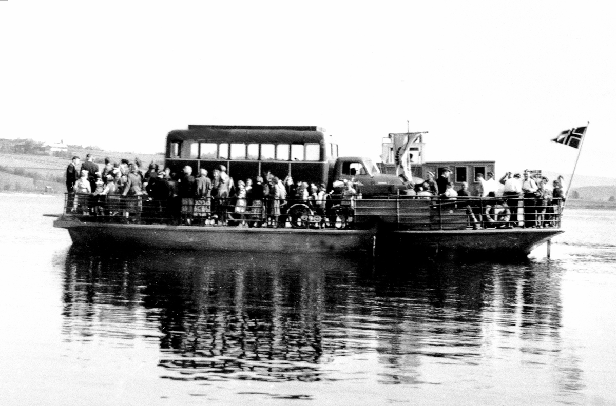 Anno Domkirkeodden, M.F. Helgøya fullt av folk og bil for 17.mai feiring. På vei fra Sundsbrygga på Helgøya. Trolig Chevrolet lastebil 1949-53 påmontert "busshus".