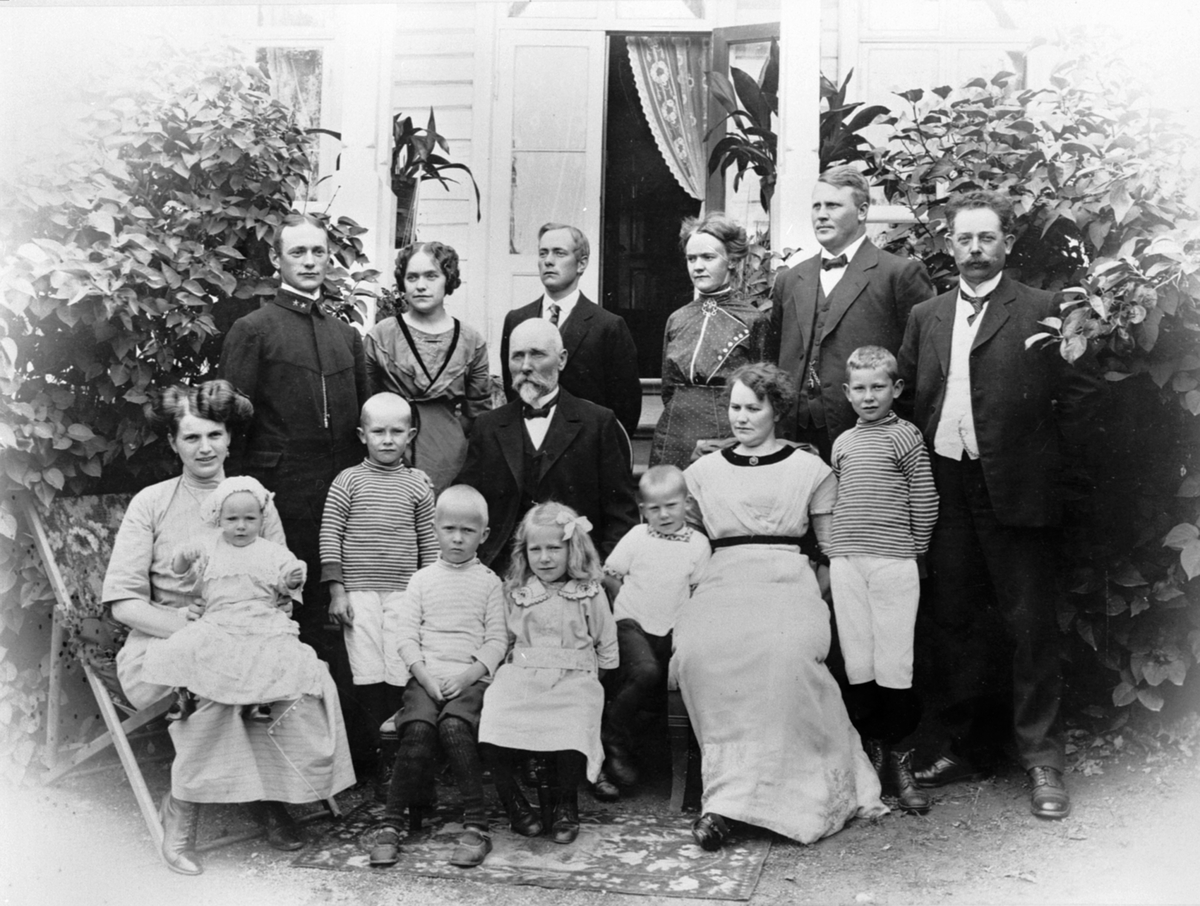 Anno Domkirkeodden, Bestyrerfamilien Navelsaker på Toftes Gave, Nedre Sund, Helgøya. Bak fra venstre er Einar Navelsaker, Inga Navelsaker, Ole Navelsaker, Anna Navelsaker, lærer Tandberg, Ivar Heggenhaugen. I midten er bestefar Nils Navelsaker. Foran fra venstre er Eva med datter Sigrid, Trygve Heggenhaugen, Olaf Tand…