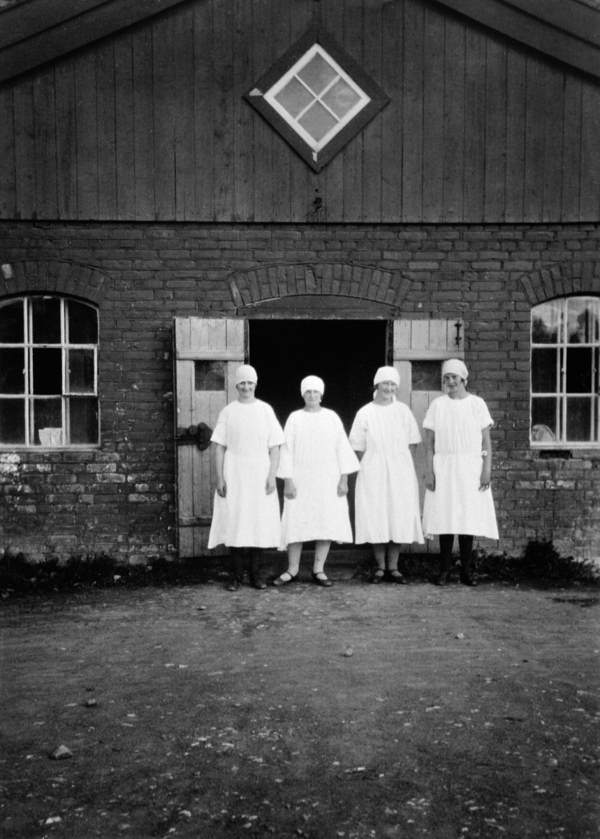 Anno Domkirkeodden, Fire budeier i fjøsdøra på Skredshoel, Ringsaker. Fra venstre er Marie Pettersen, Anna Pettersen, Klara Pettersen, Mina Brendbakken.