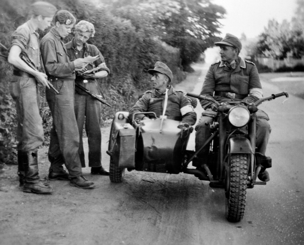 Anno Domkirkeodden, Hjemmestyrker kontrollerer 2 tyske soldater på motorsykkel med sidevogn, krigen, freden, Moelv. Motorsykkelen på bildet er en Zündapp KS750, produsert mellom 1941-1945.