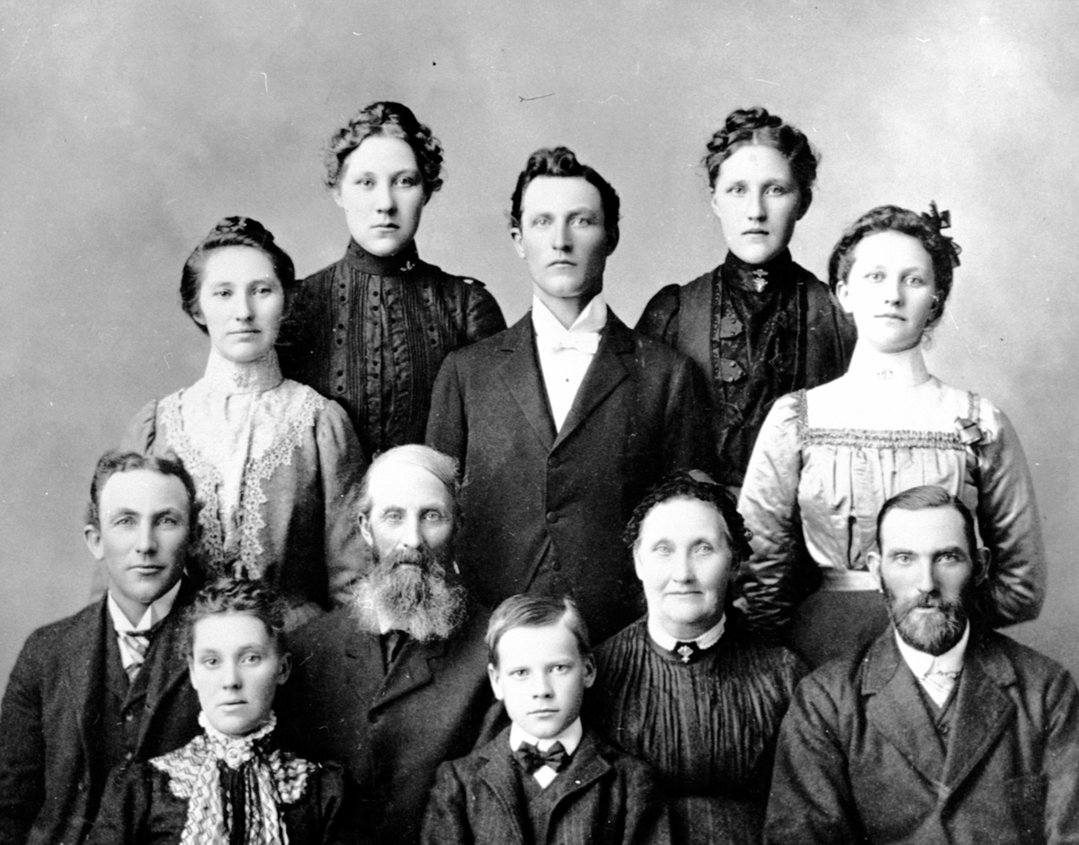 Anno Domkirkeodden, Gruppe på 11 personer. Martinius Olsen Grimsrud f.1840 og kona Andrine Eriksdatter Røråsen f.1841 med familie. Var husmann i Hanastad, Hovinsholm, Helgøya 1865-1900. Hele familien emigrerte til Amerika der dette bildet er tatt.