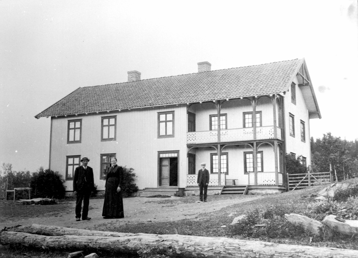 Anno Domkirkeodden, 3 personer foran hovedbygningen på Trosterud, Helgøya. Johan Larsen Ekeberg ((1859-1918), Anne Louise Larsdatter (1864-1934). Bak er trolig Lars Ekeberg Olsen f.1897.