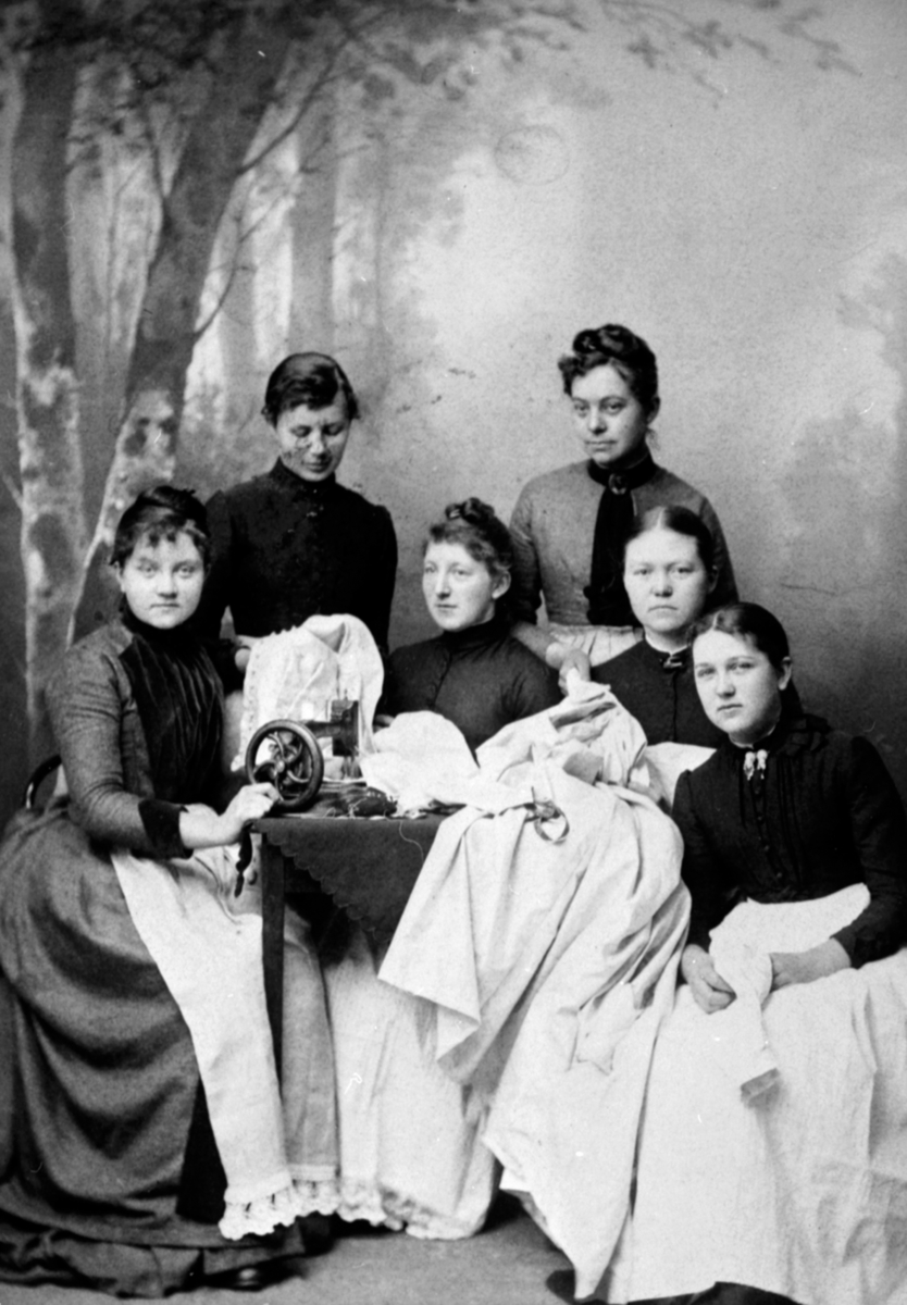 Anno Domkirkeodden, Gruppe damer med stoff og symaskin. Fra venstre er Herløv Skjønsby, Anna Helgeby f.1869, Syverine Helgeby f.1868, Martha, Karen Målfrid Heggenhaugen. De sydde utstyr til Martha som reiste til U. S. A. i 1890 årene.