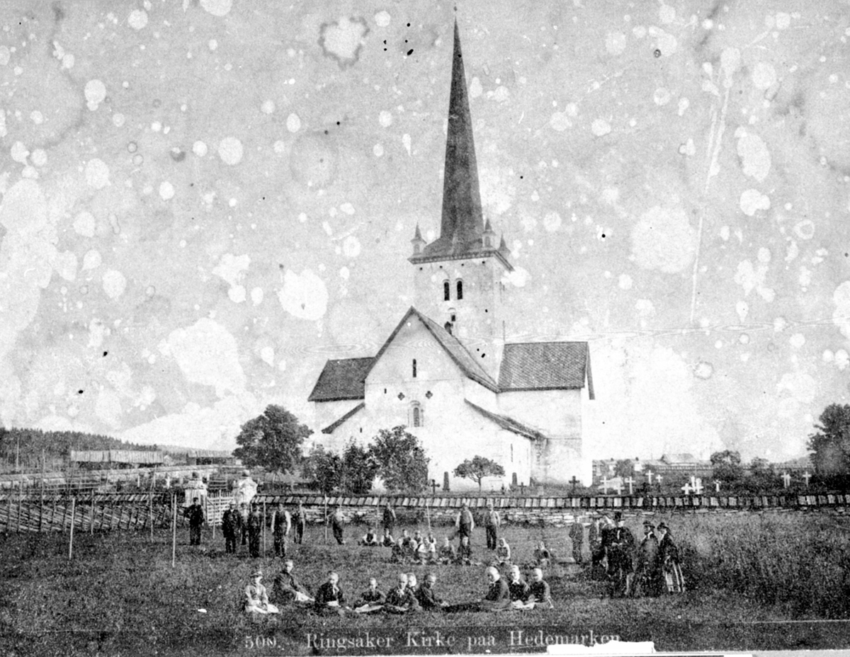 Anno Domkirkeodden, Eksteriør, Ringsaker kirke. Folk i forgrunnen utenfor kirkegårdsmuren. Prestefamilie og tjenestefolk.