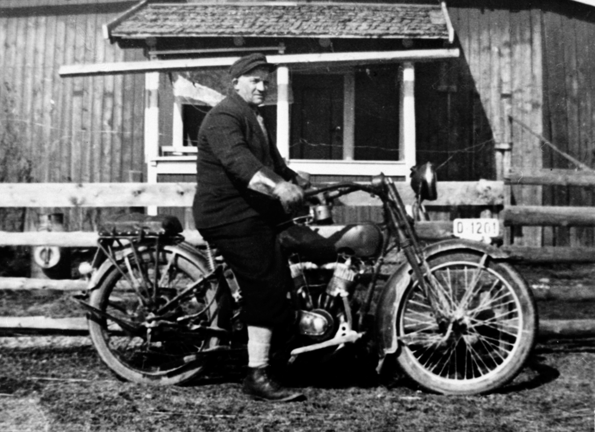 Anno Domkirkeodden, Aksel Berntsen (25.12.1894-15.03.1975) på motrosykkel, Tømtsveen under Flisaker, Veldre, Ringsaker. Harley Davidson 1000cc fra 1917-19, magnet modell som har blitt påmontert elektrisk front lukt. En kjekk detalj er at det er montert en Splitdorf dynamo nede foran motor for strøm.