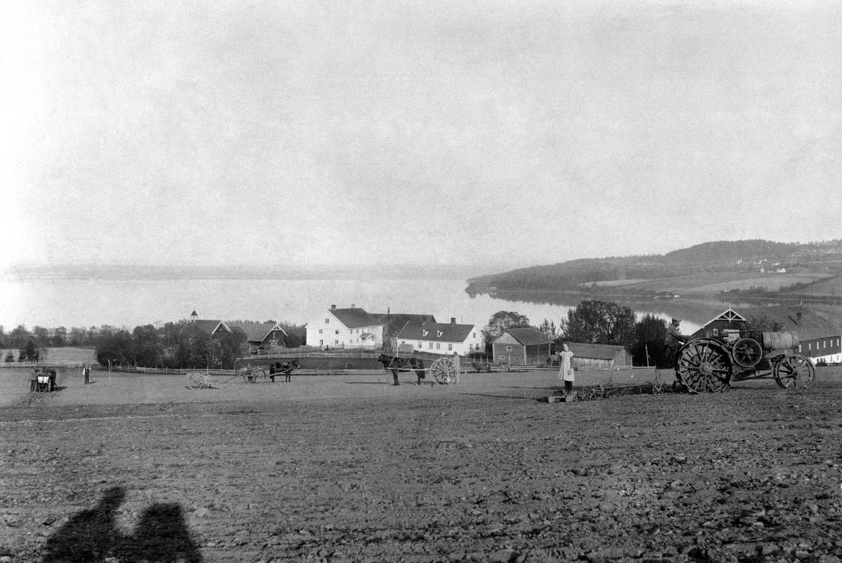 Anno Domkirkeodden, Skjelve vestre og østre, Nes, Hedmark. Våronn med "Titan" jerntraktor og hester med hesteredskap. Traktoren kjøres av Petter Ottosen. Helene Hilstad (1909-1994) på slådden.