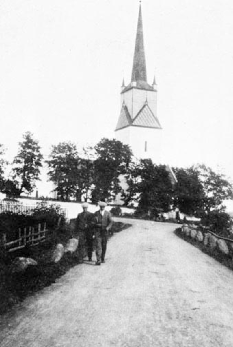 Anno Domkirkeodden, Eksteriør, Nes kirke, Ringsaker. Stabbestein langs vegen. To menn.