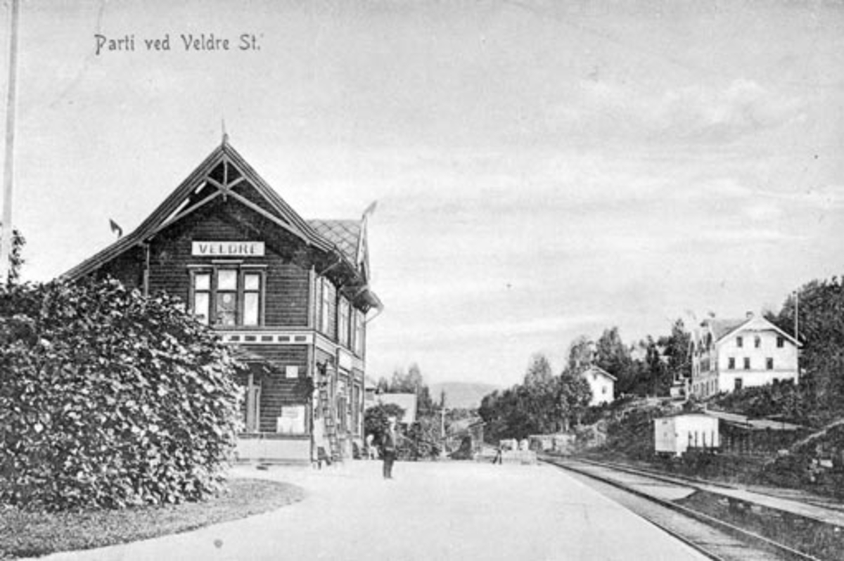 Anno Domkirkeodden, Veldre jernbanestasjon, stasjonsbygning, t.h. landhandel, butikk, postkort. "Parti ved Veldre st"