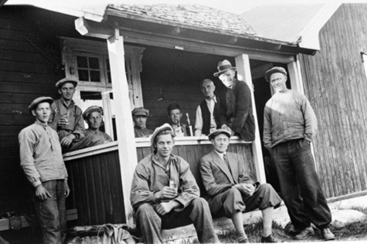 Anno Domkirkeodden, 10 vegarbeidere med pause på veranda, Bjønnåsen, Ringsakerfjellet. Nummer 6 fra venstre er Kristoffer Bjørnerud, foran til høyre er O. Langmyhr. Hos Kristoffer Bjørnerud.