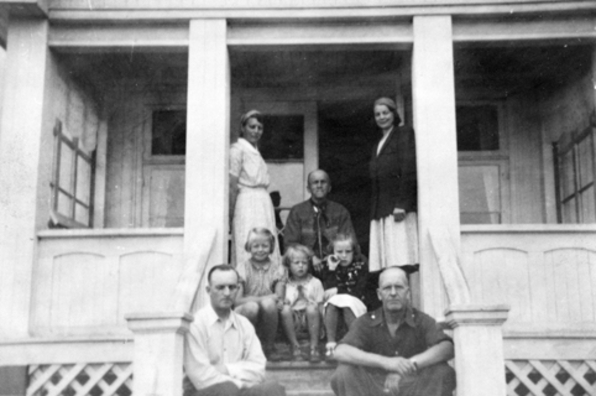 Anno Domkirkeodden, Familien Helgeby samlet på veranda på Sandvold, Nes, Hedmark. Fra venstre er Marie (1902-1979), Aslaug (1898-1977), Einar (1866-1948), Asbjørg Margrethe (1937-1998), Solveig (1944-1991), ?, Håkon (1906-1988), gjest.