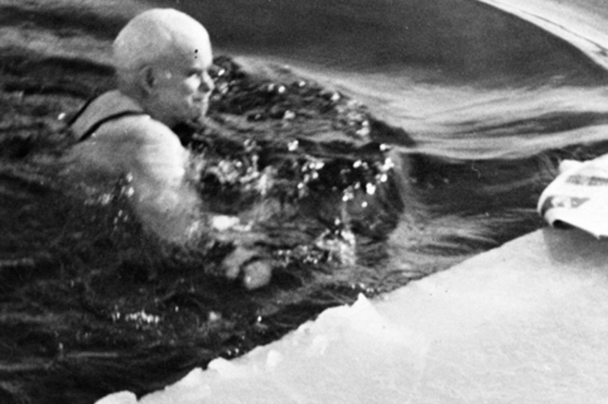 Anno Domkirkeodden, Isbading. Emil Husebye svømmer i råka ved Nerkvernbrygga, Brumunddal. 18 kuldegrader. Mjøsa er islagt.