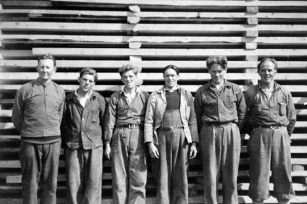 Anno Domkirkeodden, Langmosaga, Brumunddal. Gruppe menn oppstillt foran plankestabel. Fra venstre er Einar Skogstad, Olav Landgård, Johan Aaseth, Arne Sveberg, Guttorm Aaseth, Ole Olsen,.