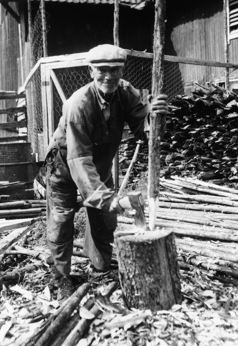 Anno Domkirkeodden, Gårdsarbeider Olaf Olsen Bakken spisser gjerdestaur med øks på Arnkværn gård, Furnes, Ringsaker.