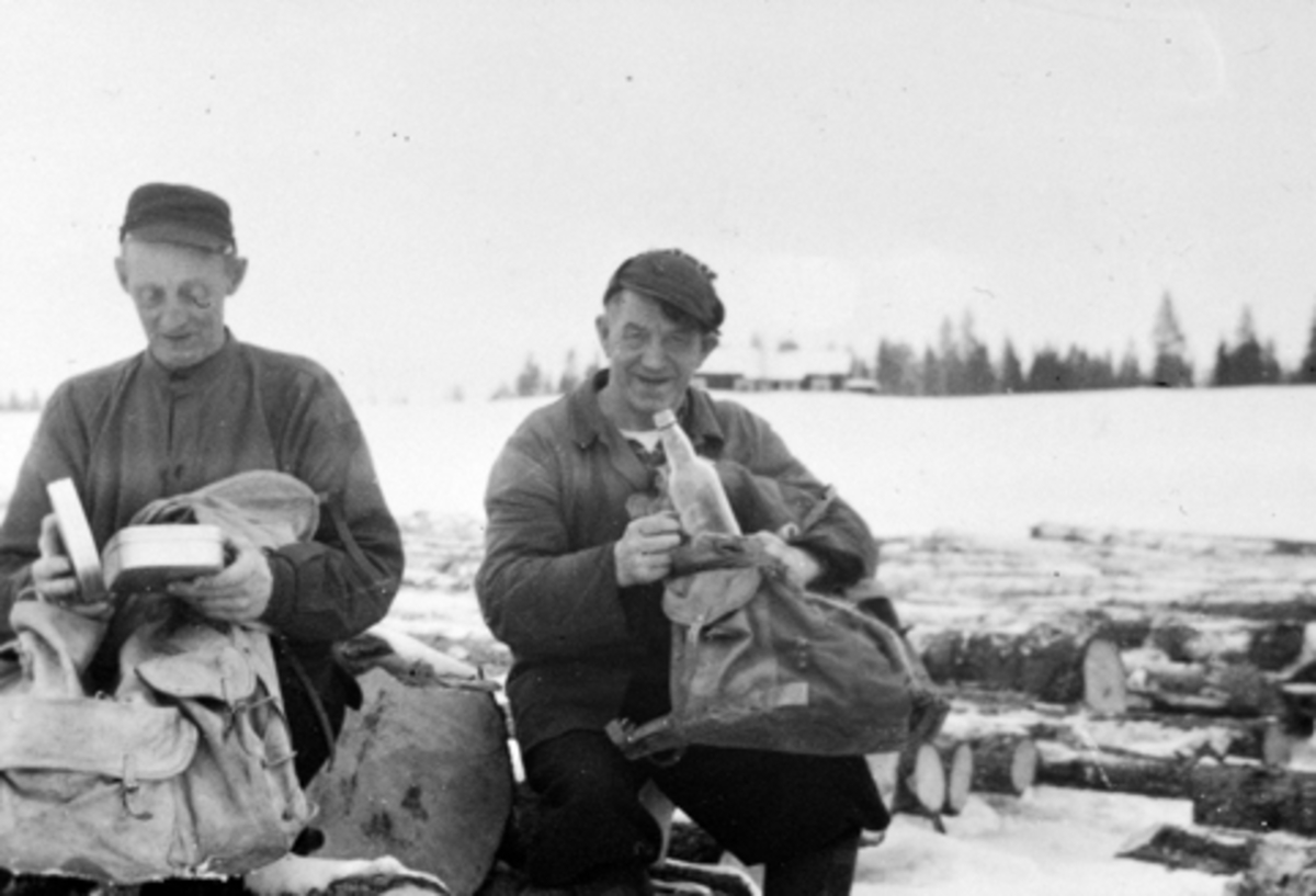 Anno Domkirkeodden, Leikvoldsaga, Furnes Almenning. Arne Kvarstad og Einar Vestvold spiser nistemat utendørs. Vinter.